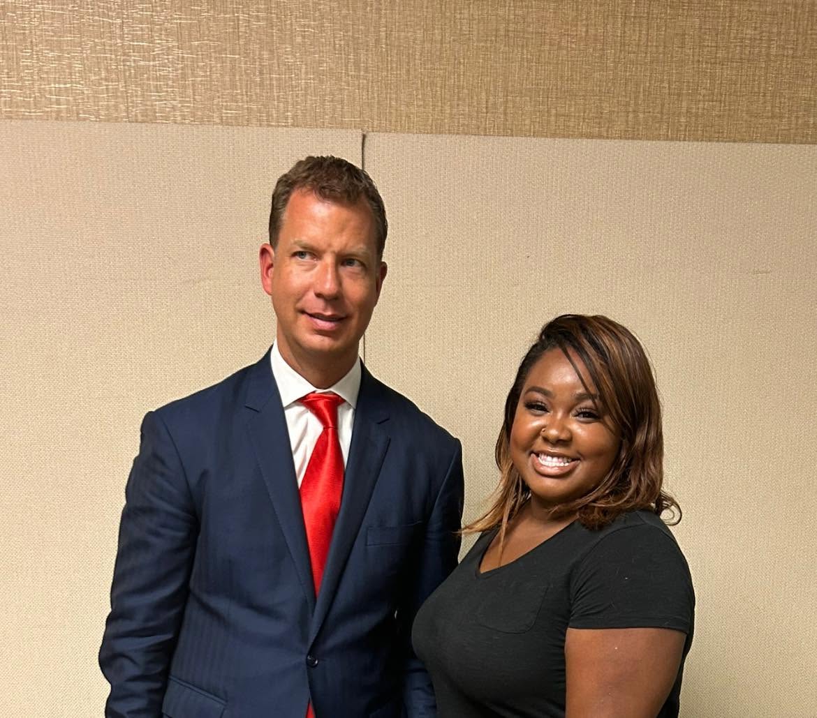 Erika Nicole with a speaker at a business conference